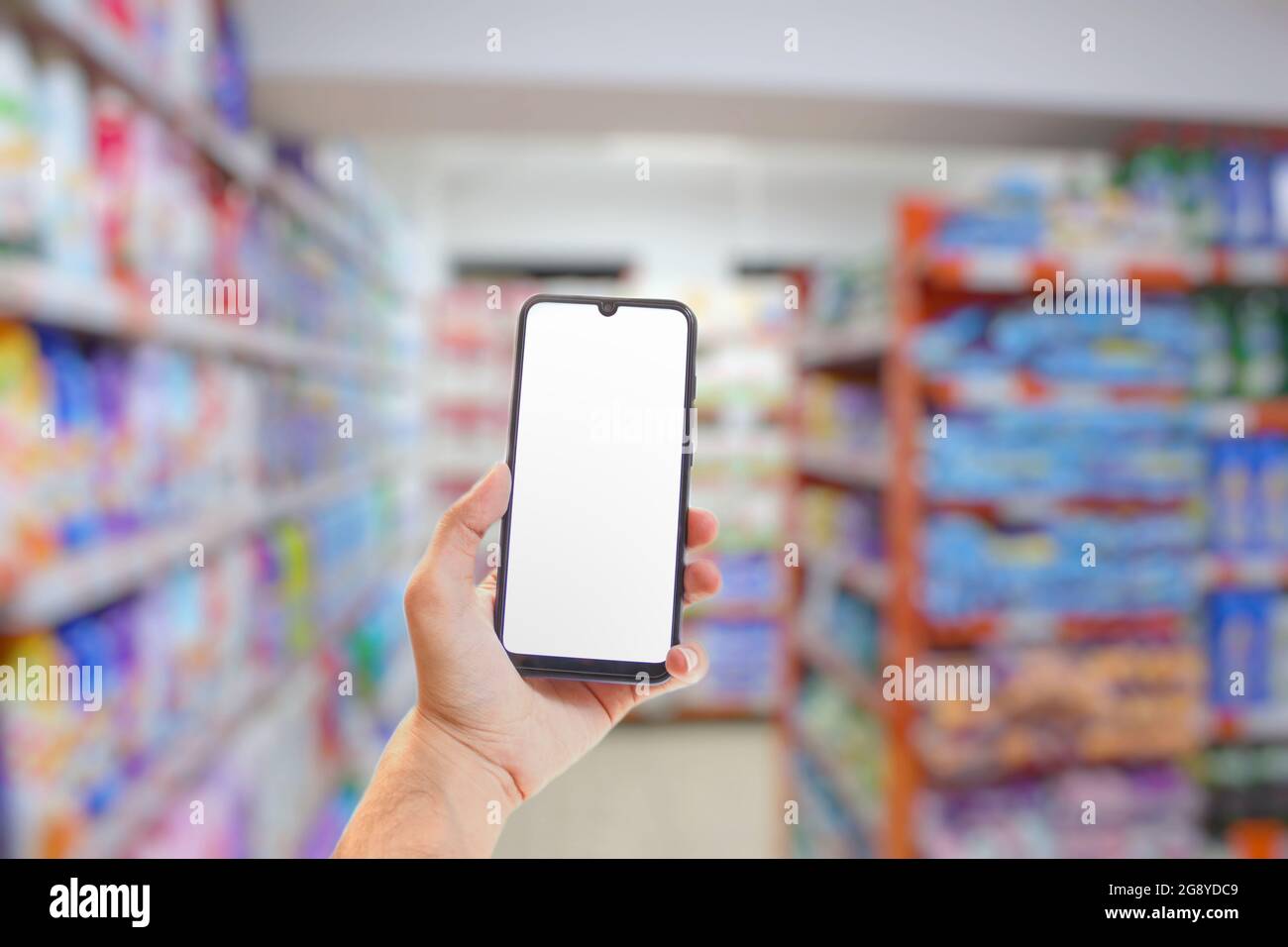 Person holding a smartphone in a shop setting